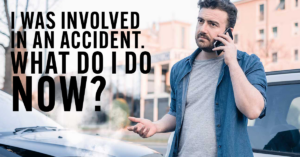 a guy speaking on phone in front of his damaged car