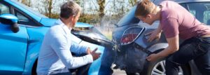 Drivers inspecting car accident damage